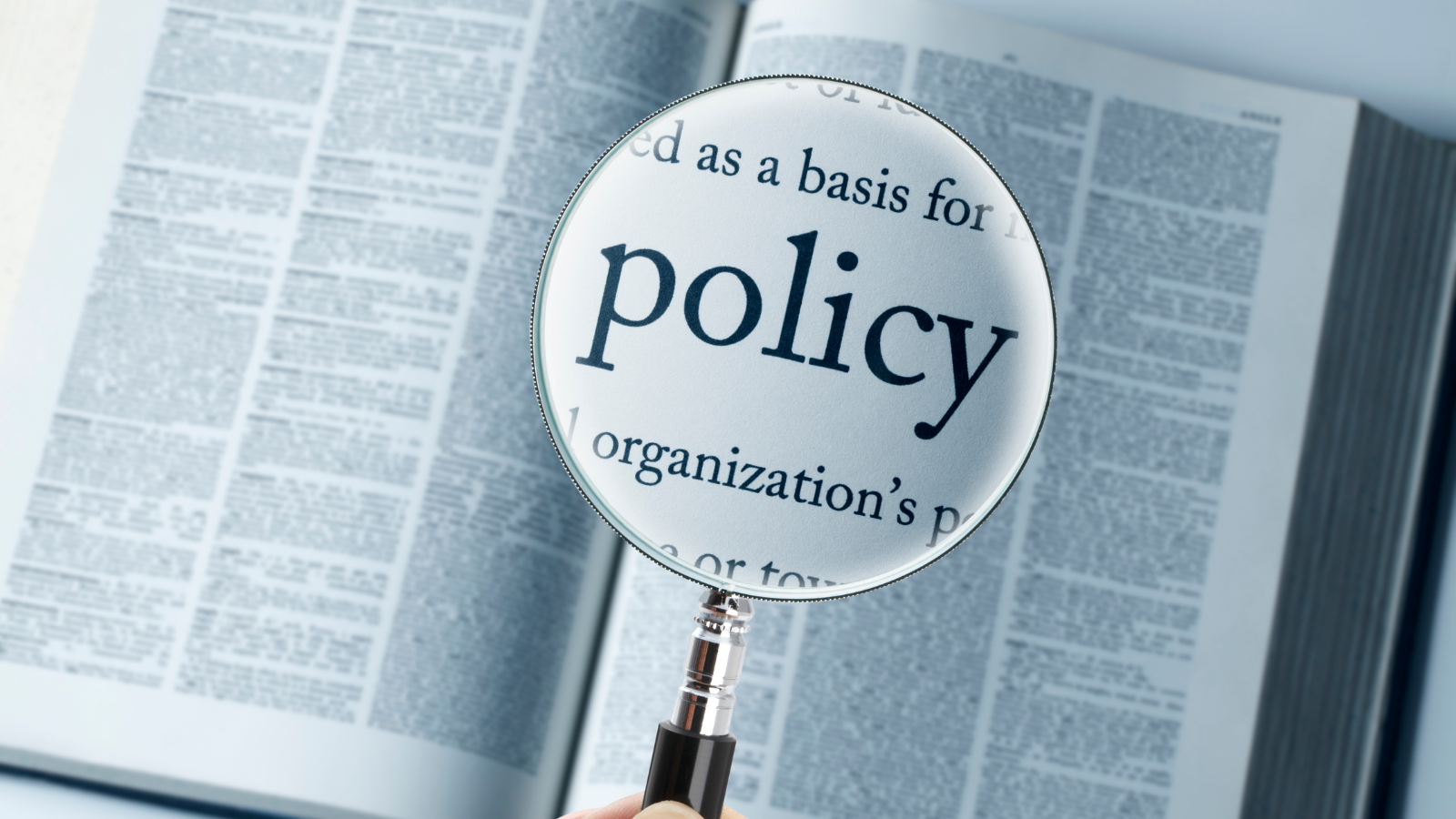 Magnifying glass over a book with the word policy
